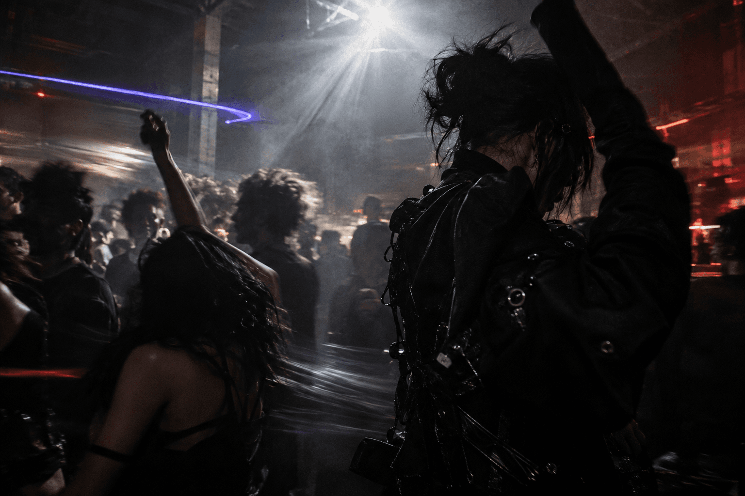 Dancers, silver strobe light and motion trails on a crowded underground dancefloor
